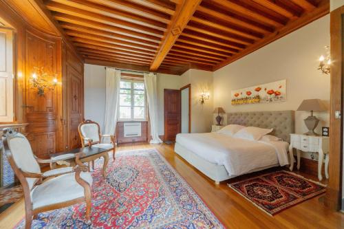 1 dormitorio con cama, escritorio y silla en Château de Briante en Saint-Lager