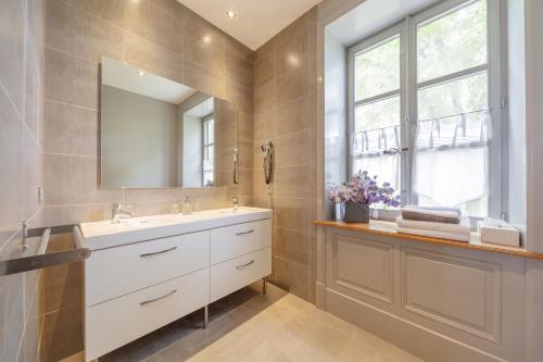 uma casa de banho com um lavatório branco e um espelho. em Château de Briante em Saint-Lager