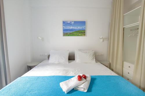 a bedroom with a bed with towels on it at Porto Bello di Paros in Parikia