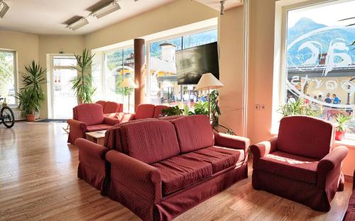 sala de estar con sillas, sofá y TV en House Budkovič en Bohinj