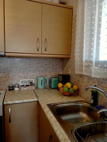 a kitchen with a sink and a bowl of fruit at Myilios Leisure Piraeus by Ilios Company in Piraeus