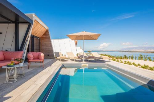an infinity pool with chairs and an umbrella on a house at Aminess Style Glamping Villas & Holiday Homes Avalona in Povljana