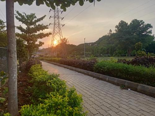 eine Backsteinstraße mit Sonnenuntergang im Hintergrund in der Unterkunft Mahagiri Nest in Mysore