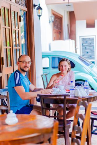 Un hombre y una mujer sentados en una mesa en un restaurante. en The Norfolk Heritage Airport Villa, en Katunayake