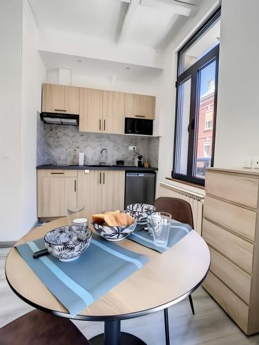 une cuisine et une salle à manger avec une table et des chaises dans l'établissement La Licorne, grand studio chaleureux, à Amiens