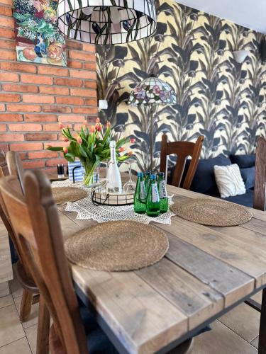 a wooden table with chairs and a dining room at Piękna Góra in Giżycko