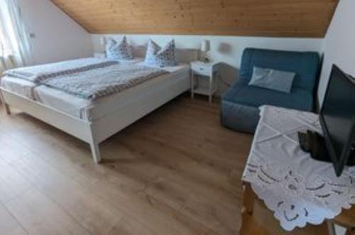 une chambre avec un lit et une chaise bleue dans l'établissement Ferienwohnung zum Wohlfühlen, à Altensteig