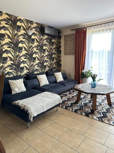 a living room with a blue couch and a table at Piękna Góra in Giżycko