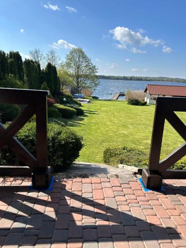a brick walkway with two wooden gates and a view of a park at Piękna Góra in Giżycko