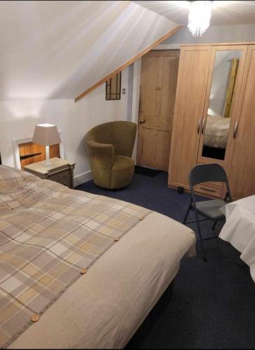 a bedroom with a bed and a chair and a desk at Victorian Gate House Own Bathroom in Solihull