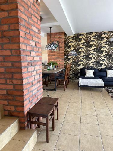 a room with a brick wall and a table and chairs at Piękna Góra in Giżycko