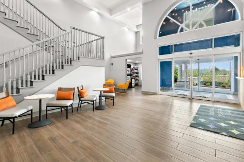 a lobby with tables and chairs and stairs at Spark by Hilton Commerce, GA in Commerce
