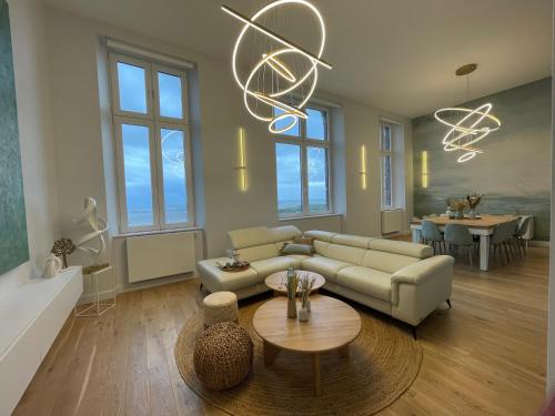 a living room with a couch and a table at FACE MER PIEDS DANS L'EAU DUPLEX 4 Chambres 155 M2 8-12 personnes in Berck-sur-Mer