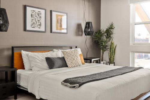 a bedroom with a large white bed with pillows at New! Sprawling Floor Plan - Central LoHi - Peloton in Denver