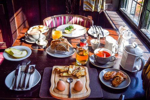 a wooden table with breakfast food on it at Rising Sun Hotel in Lynmouth