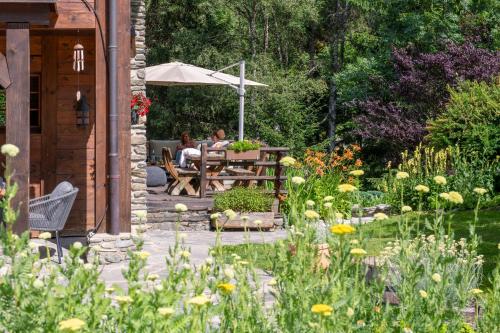 two people sitting at a table in a garden at Chalet Cinq Moutons in Orsières
