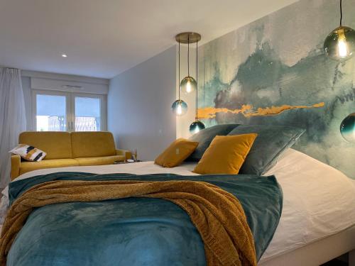 a bedroom with a large bed with a painting on the wall at FACE MER PIEDS DANS L'EAU DUPLEX 4 Chambres 155 M2 8-12 personnes in Berck-sur-Mer