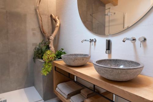 two sinks on a wooden counter in a bathroom at ARPA DI PIETRA - Luxury B&B SPA BIO - Adults Only in Mori