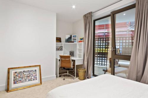 um quarto com uma cama, uma secretária e uma janela em 2 Bedroom flat near shops and restaurants em Londres