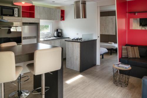 a small kitchen and living room with red walls at Camping du Château Vert in Hondainville