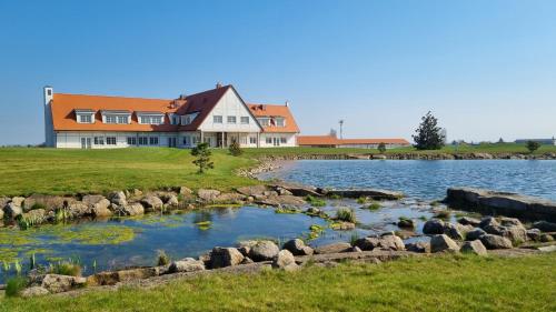 a house on the shore of a lake with rocks at Apartments by Prague City Golf in Prague