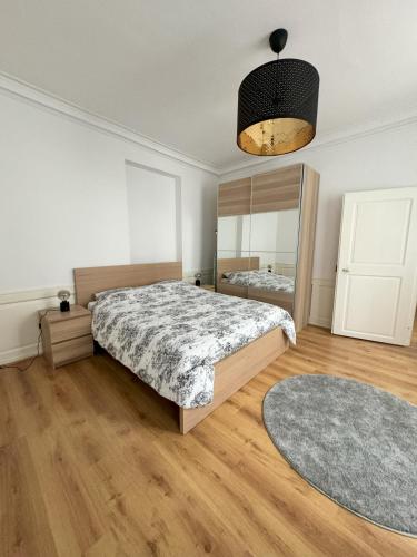 une chambre avec un lit et un grand miroir dans l'établissement Magnifique appart côté Cathédrale, à Strasbourg