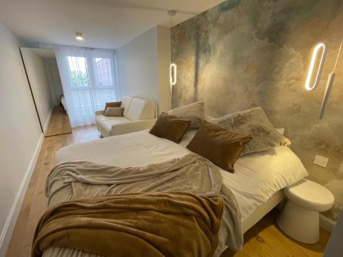 a bedroom with a large bed and a couch at FACE MER PIEDS DANS L'EAU DUPLEX 4 Chambres 155 M2 8-12 personnes in Berck-sur-Mer