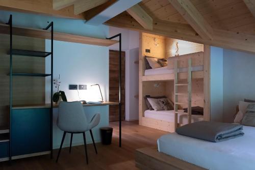 1 dormitorio con literas, escritorio y silla en ARPA DI PIETRA - Luxury B&B SPA BIO, en Mori