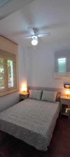 a bedroom with a bed and two lights on two tables at El laurel y el limonero. in Las Pajanosas