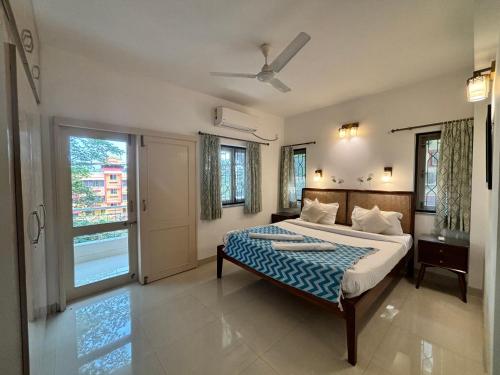 een grote slaapkamer met een bed en een raam bij Quintara Serviced Apartments in North Goa in Porvorim