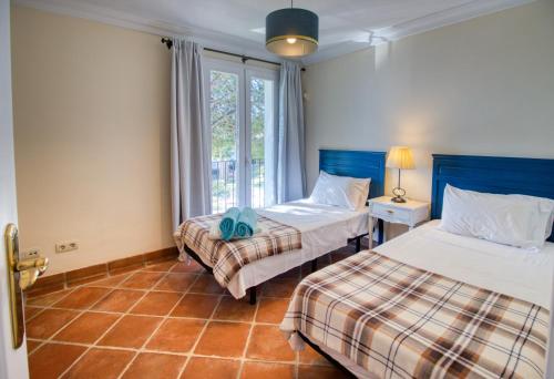 a bedroom with two beds and a window at La Perla De La Bahia in Bahia de Casares