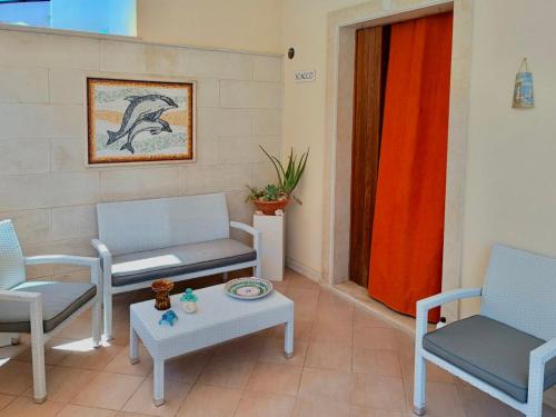 ein Wohnzimmer mit zwei Stühlen und einem Tisch in der Unterkunft Casa Vacanza Mare Blu in Villaggio Azzurro