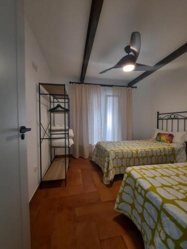 a bedroom with two beds and a ceiling fan at El rincón de Manolita #3 in Bornos