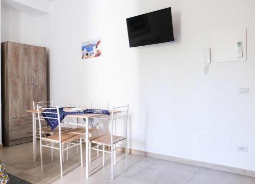 a room with a table and chairs and a tv at Lipari - Casa Centro Storico in Lipari