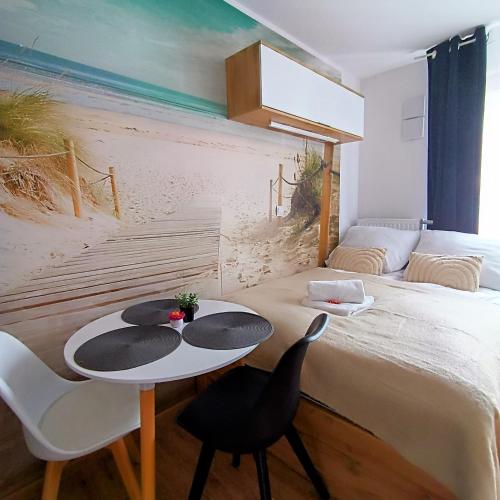 a bedroom with a bed with a table and chairs at Ama Molto Apartments in Wrocław