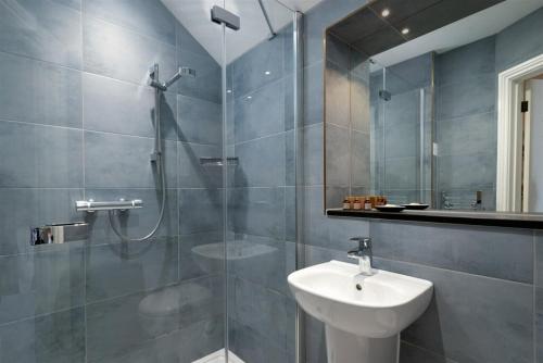 a bathroom with a shower and a sink and a mirror at Rock House Hotel in Lynmouth