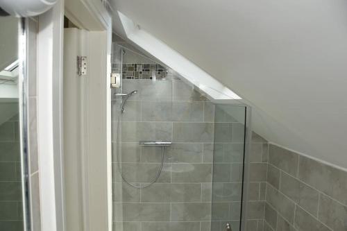 a shower with a glass door in a bathroom at Luxurious apartment near the sea in Dun Laoghaire