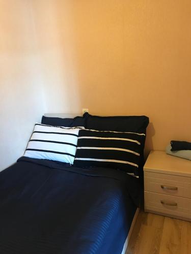 ein Schlafzimmer mit einem blauen Bett und einem gestreiften Kissen in der Unterkunft Homee in Tbilisi City