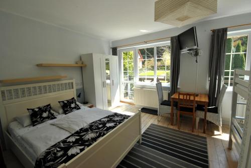 une chambre avec un lit, un bureau et des fenêtres dans l'établissement Willa Szyszka, à Karpacz