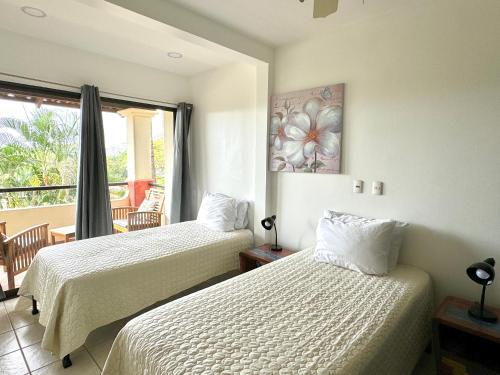 1 dormitorio con 2 camas y balcón en Rooftop Sunset Cove, en Liberia