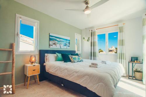 ベニタチェルにあるVilla Sea Breeze by Abahana Villasのベッドルーム1室(大型ベッド1台、窓2つ付)