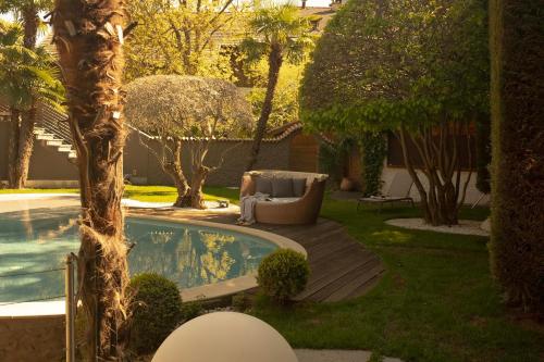 a backyard with a pool and a chair and a tree at Hotel Mühlbacherhof in Lagundo