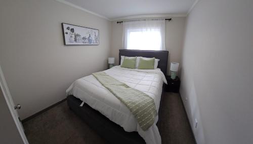 1 dormitorio con 1 cama grande con almohadas verdes en 3 bedroom Town in Stonebridge unit 303 en Saskatoon