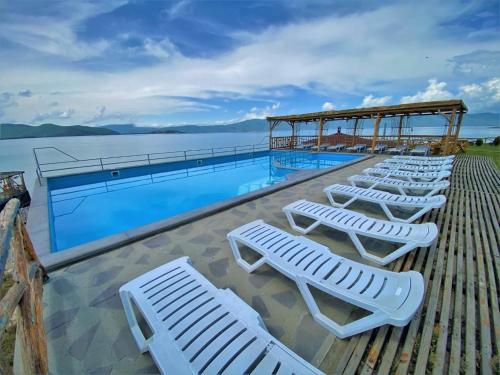 a row of lounge chairs next to a swimming pool at Tsovasar Family Rest Complex in Sevan