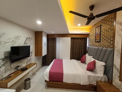 Schlafzimmer mit einem Bett und einem Flachbild-TV in der Unterkunft Hotel RK ICON in Ahmedabad