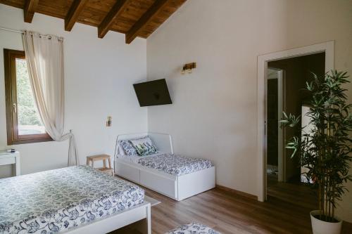 Habitación con cama, sofá y ventana en LA CASETTA Malpensa Guesthouse en Case Nuove