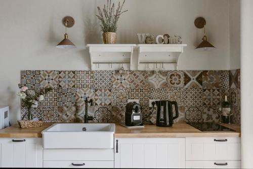 a kitchen with a sink and a tile wall at LA CASETTA Malpensa in Case Nuove