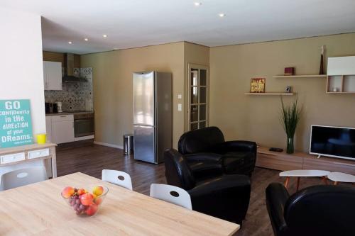 une cuisine et un salon avec une table et des chaises dans l'établissement Le Vieil Olivier 1, à Cornillon