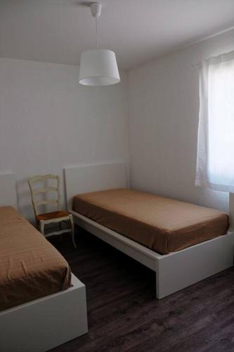 une chambre avec deux lits et une chaise et une fenêtre dans l'établissement Le Vieil Olivier 1, à Cornillon