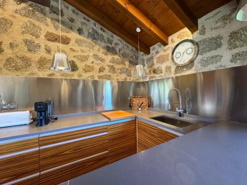 a kitchen with a sink and a clock on the wall at Complejo Rural Los Cachos in Baterna